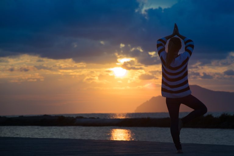 Vrouw bij zee in yoga houding / 🧘‍♀️ 18 juni – Internationale Dag van de Yoga