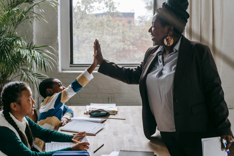 lerares geeft een high five aan een schoolkind in de klas (🍎 Dag van de Leraar – 5 oktober 2025)