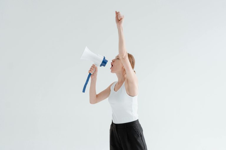 Vrouw die roept door een megafoon - 🕊️ Dag van de Mensenrechten – 10 december