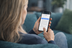 Blond vrouw met smartphone op de bank met google en een AI antwoord