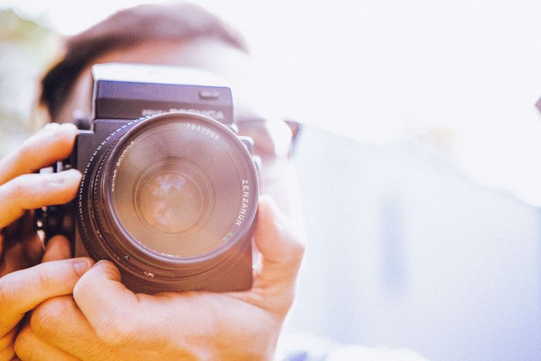 Professionele fotograaf met een camera in zijn hand maakt afbeeldingen voor een website
